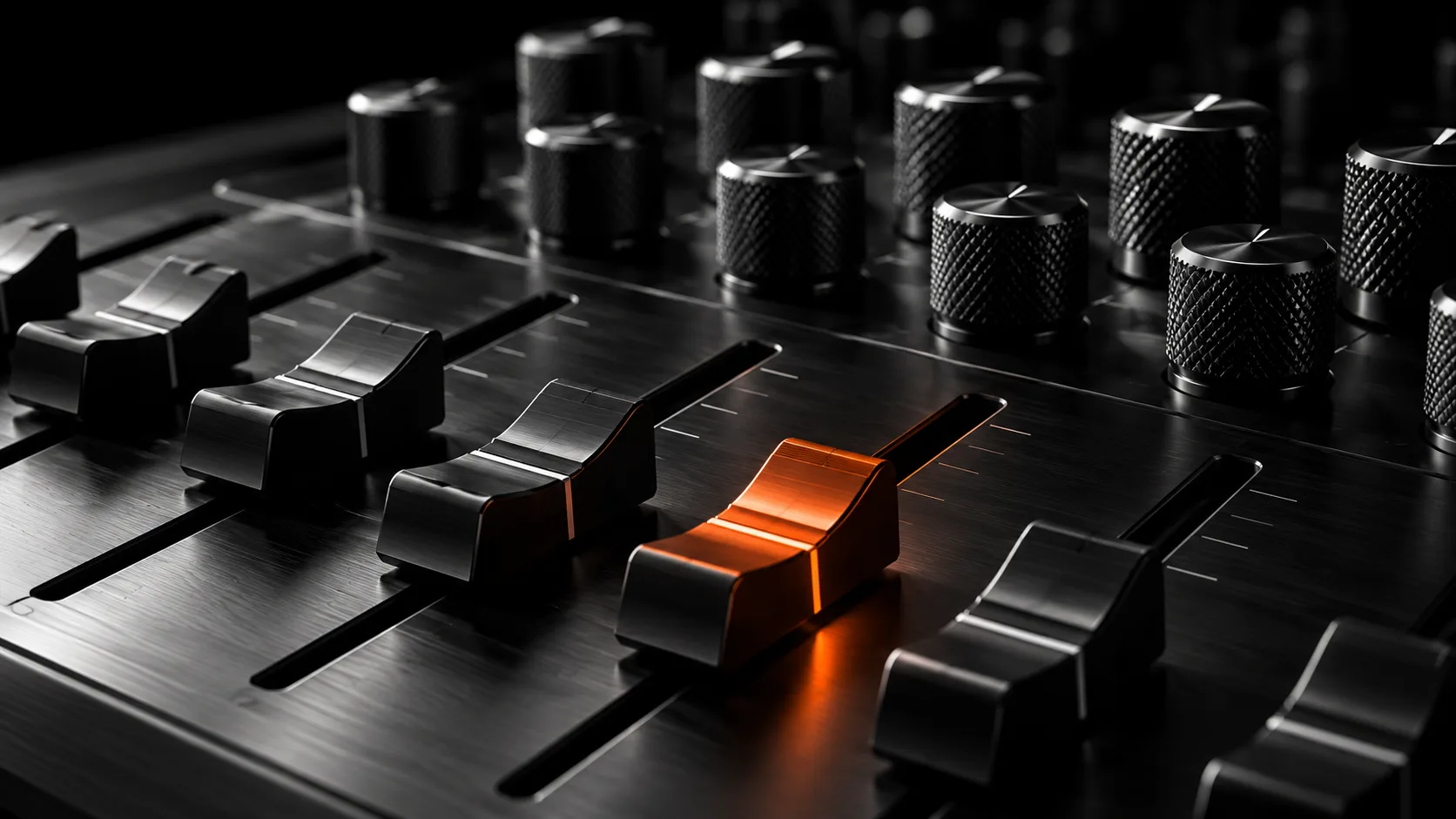 Consola de control con perillas y faders de metal, uno iluminado en naranja